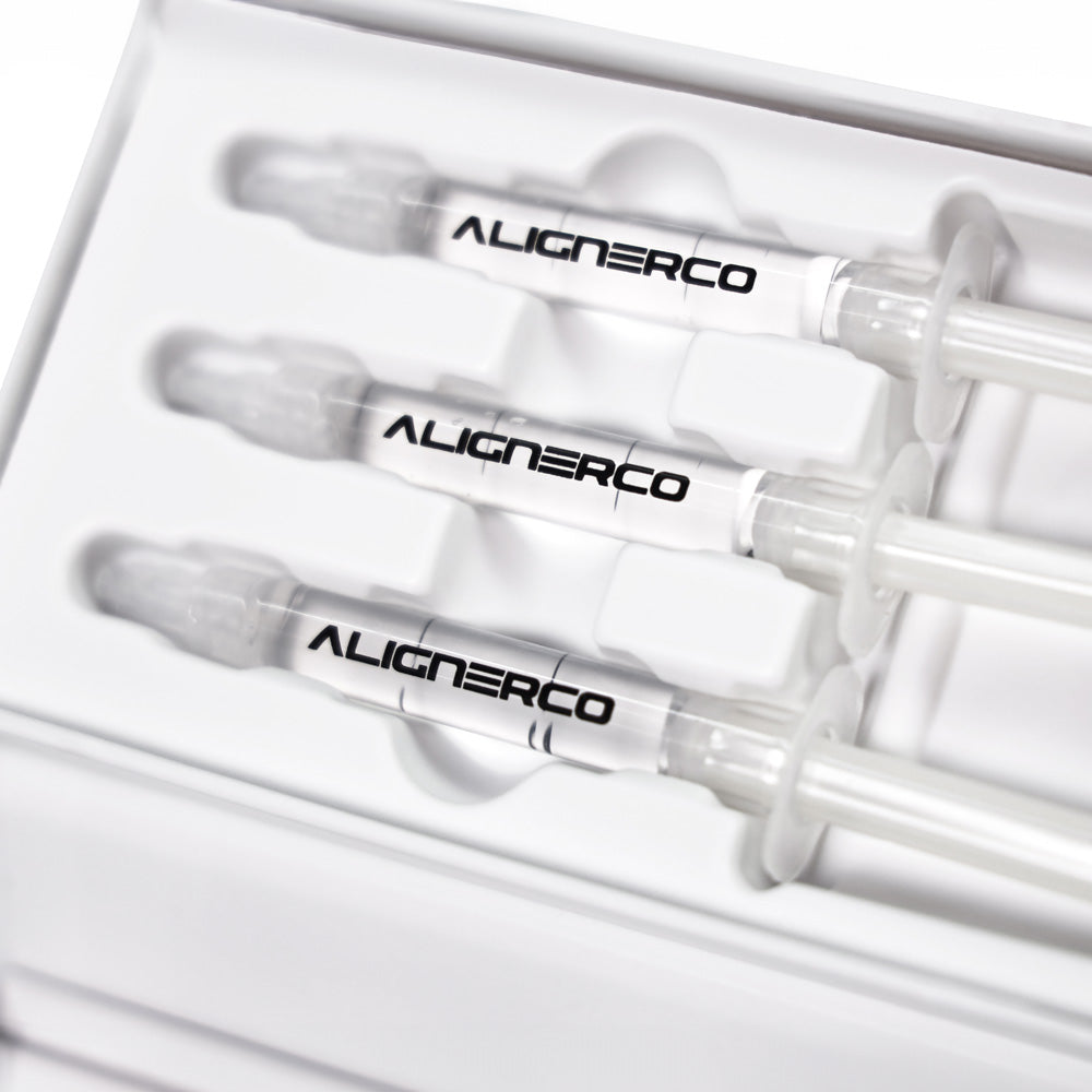 Close-up of Alignerco whitening gel syringes neatly placed in white packaging tray.