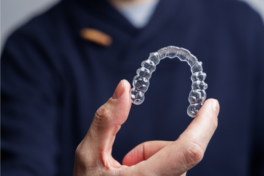 A boy is holding an invisible aligner