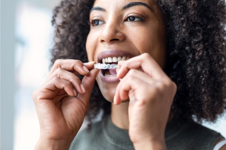 A woman putting in her removable braces