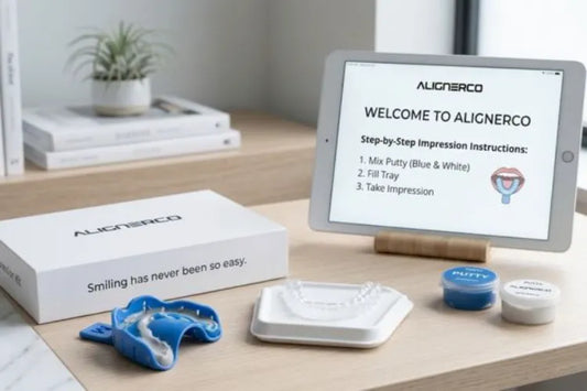  A tabletop setup featuring an ALIGNERCO impression kit, at-home clear aligners, and a tablet with instructions.
