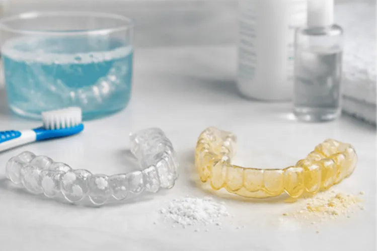  An image showing a yellow night guard and a clean night guard.