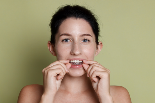 A woman wearing clear aligners.
