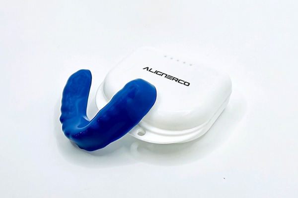 A customized ALIGNERCO Mouth Guard placed on its container