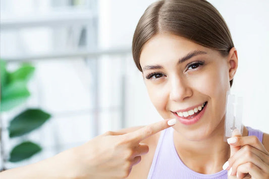 a girl holding whitening strips