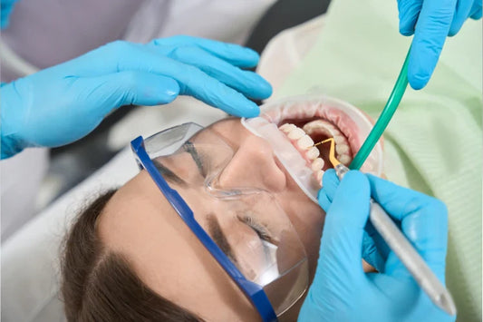Dental professionals performing dental scaling on a patient.